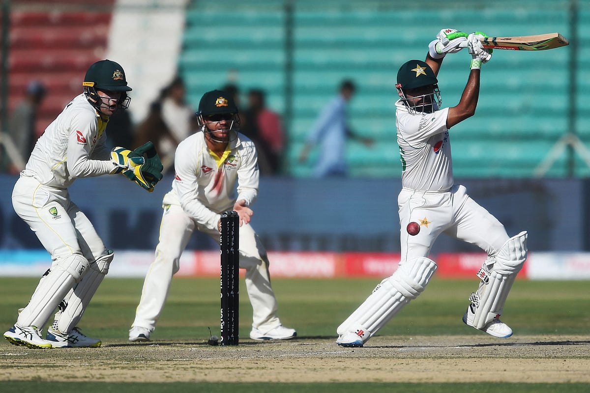 Pakistan's captain Babar Azam (R) plays a shot during the fifth and final day of the second Test cricket match between Pakistan and Australia at the National Cricket Stadium in Karachi on 16 March 2022.
