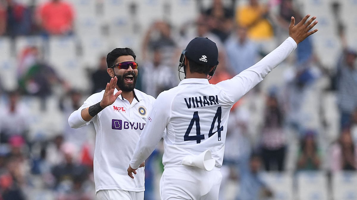 India's Ravindra Jadeja (L) and teammate Hanuma Vihari celebrate after the dismissal of Sri Lanka's Angelo Mathews during the third day of the first Test cricket match between India and Sri Lanka at the Punjab Cricket Association Stadium in Mohali on 6 March 2022.