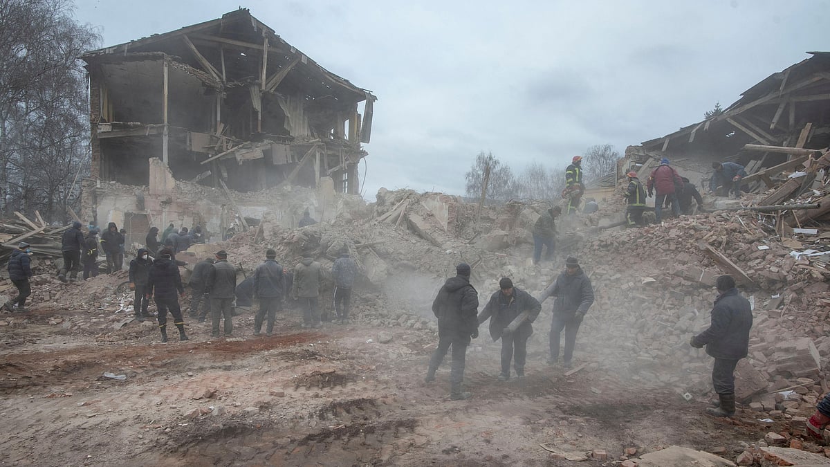 People remove debris at the site of a military base building that, according to the Ukrainian ground forces, was destroyed by an air strike, in the town of Okhtyrka in the Sumy region, Ukraine 28 February 2022.