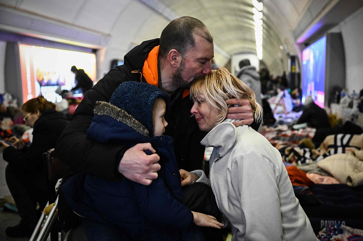 Sergyi Badylevych (C), 41, hugs his wife Natalia Badylevych (R), 42, and baby in an underground metro station used as bomb shelter in Kyiv on March 2, 2022. On the seventh day of fighting in Ukraine Russia claims control on 2 March 2022 of the southern port city of Kherson, street battles rage in Ukraine's second-biggest city Kharkiv, and Kyiv braces for a feared Russian assault.