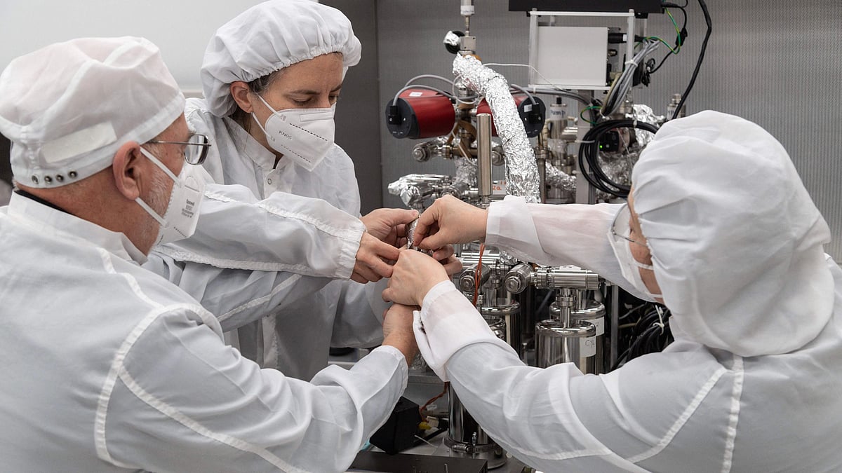 This handout photo released by NASA Shows (from L) Dr. Juliane Gross, Astromaterials Research and Exploration Science Division (ARES) deputy Apollo curator, alongside Drs. Alex Meshik, and Olga Pravdivtseva, from Washington University in St. Louis, beginning a gas extraction process using the manifold (a device to extract and collect the gas) on one of the last unopened, Apollo-era lunar samples on 11 February 2022 at NASA's Johnson Space Center in Houston