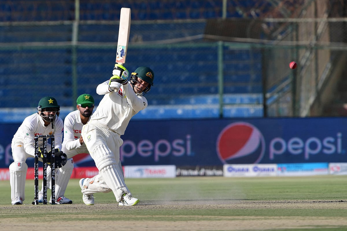 Australia's wicketkeeper Alex Carey (R) plays a shot during the second day of the second Test cricket match between Pakistan and Australia at the National Cricket Stadium in Karachi on 13 March, 2022.