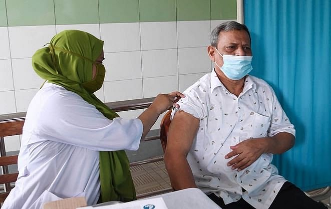 A health worker administers Covid-19 vaccine to a person