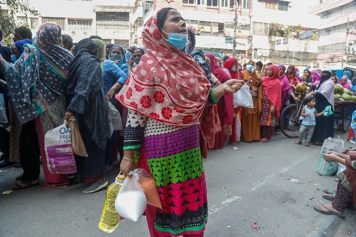 People crowd in front of the Trade Corporation of Bangladesh (TCB) truck to buy the essential commodities at fair prices. The picture was taken from Hatirpul area in Dhaka on 16 March.