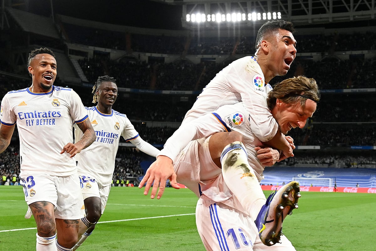 Real Madrid's Croatian midfielder Luka Modric (R) celebrates with teammates after scoring a goal during the Spanish league football match between Real Madrid CF and Real Sociedad at the Santiago Bernabeu stadium in Madrid on 5 March, 2022
