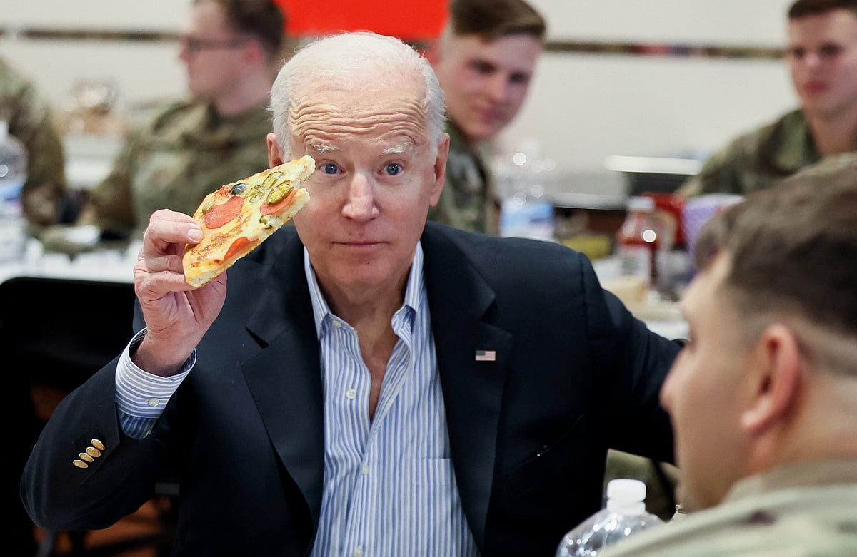 US president Joe Biden eats pizza as he meets with US Army soldiers assigned to the 82nd Airborne Division at the G2 Arena in Jasionka, near Rzeszow, Poland, 25 March 2022