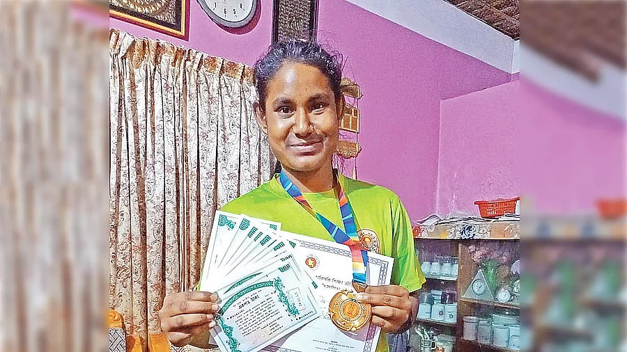 Jasmine displays her medal, certificates and prizes