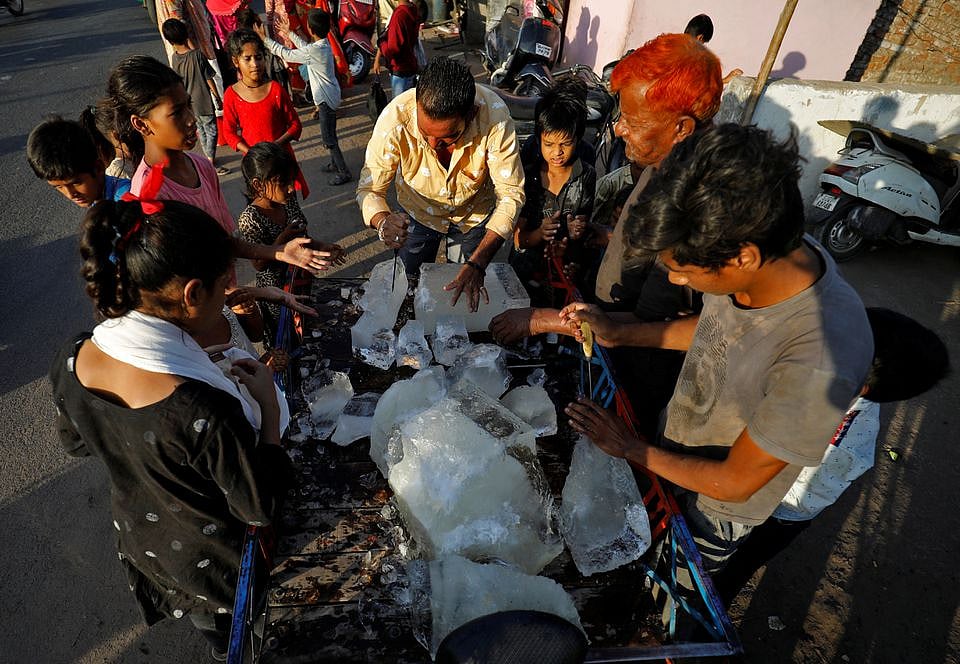 A man breaks a block of ice to distribute it among the residents of a slum during hot weather in Ahmedabad, India, April 28.