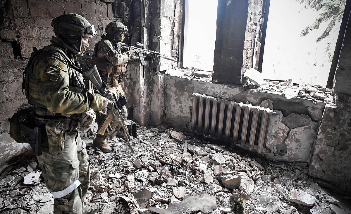Two Russian soldiers patrol in the Mariupol drama theatre, bombed last March 16, in Mariupol on 12 April, 2022, as Russian troops intensify a campaign to take the strategic port city