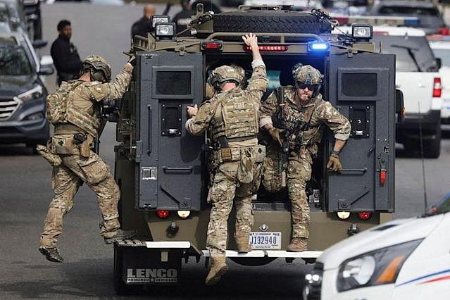An FBI tactical team deploys from an armored vehicle at the scene of a reported shooting and active shooter near Edmund Burke Middle School in the Cleveland Park neighborhood of Northwest Washington.