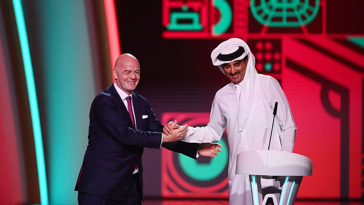 FIFA President Gianni Infantino (L) greets Qatar's Emir Sheikh Tamim bin Hamad al-Thani (R) during the draw for the 2022 World Cup in Qatar