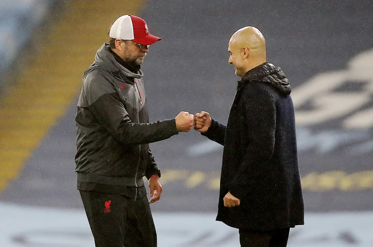 Manchester City manager Pep Guardiola and Liverpool manager Juergen Klopp bump fists after a match between the two clubs on 8 November 2020