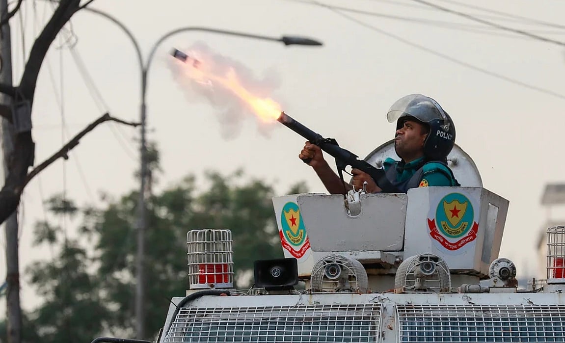 A policeman fires a tear shell canister during the clash to bring the situation under control