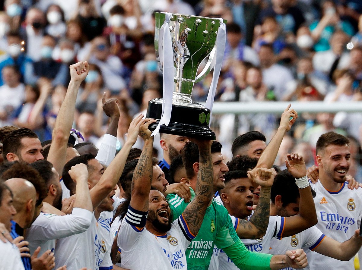 Real Madrid's Marcelo holds the trophy and celebrates with team members after winning La Liga on 30 April, 2022.
