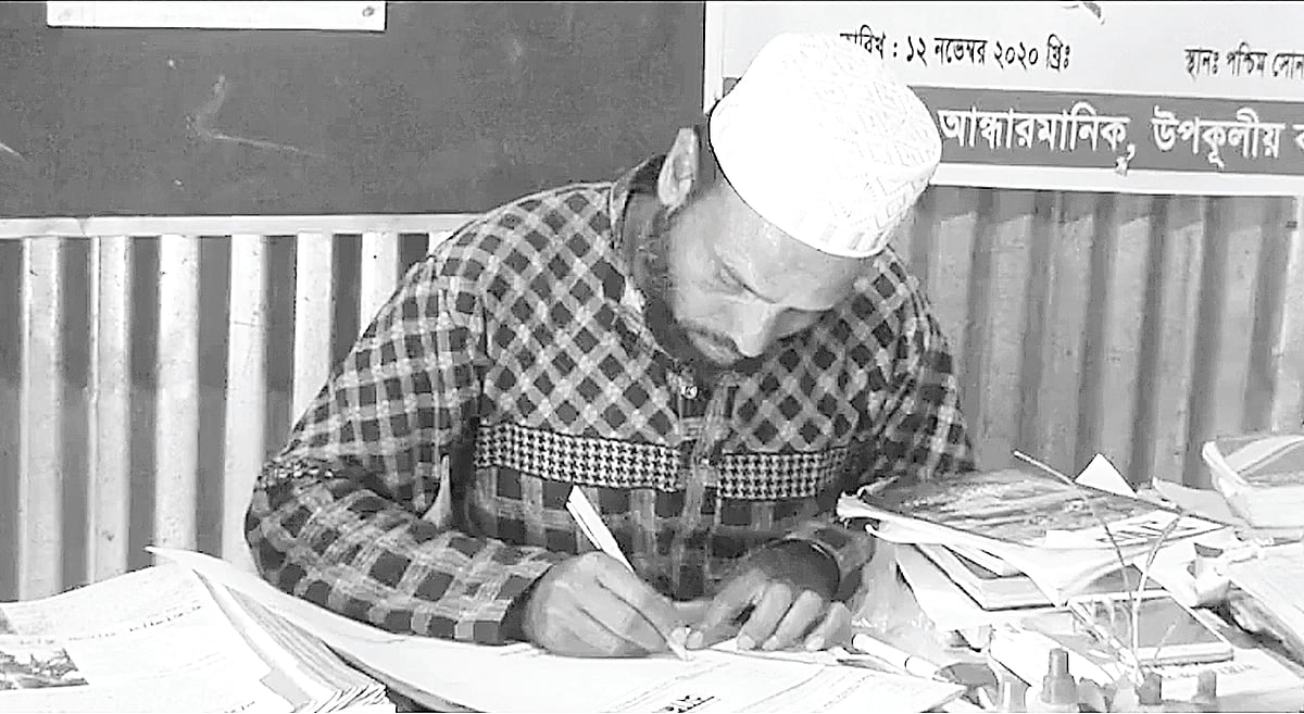 Hasan Parvez writing reports for his handwritten newspaper 'Andharmanik'. Photo taken from Patuakhali's Kalapara on Friday.