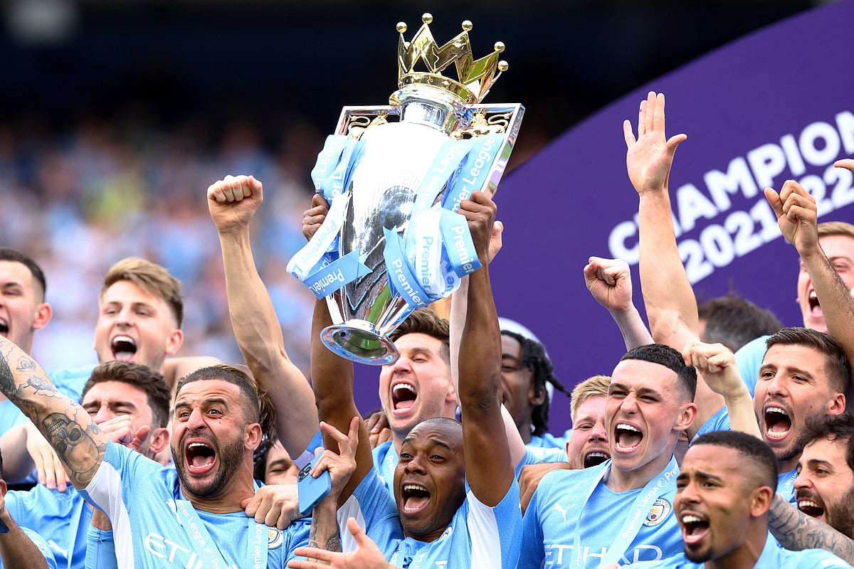 Manchester City's Brazilian midfielder Fernandinho lifts the Premier League trophy as City players celebrate on the pitch after the English Premier League football match between Manchester City and Aston Villa at the Etihad Stadium in Manchester, north west England, on 22 May, 2022