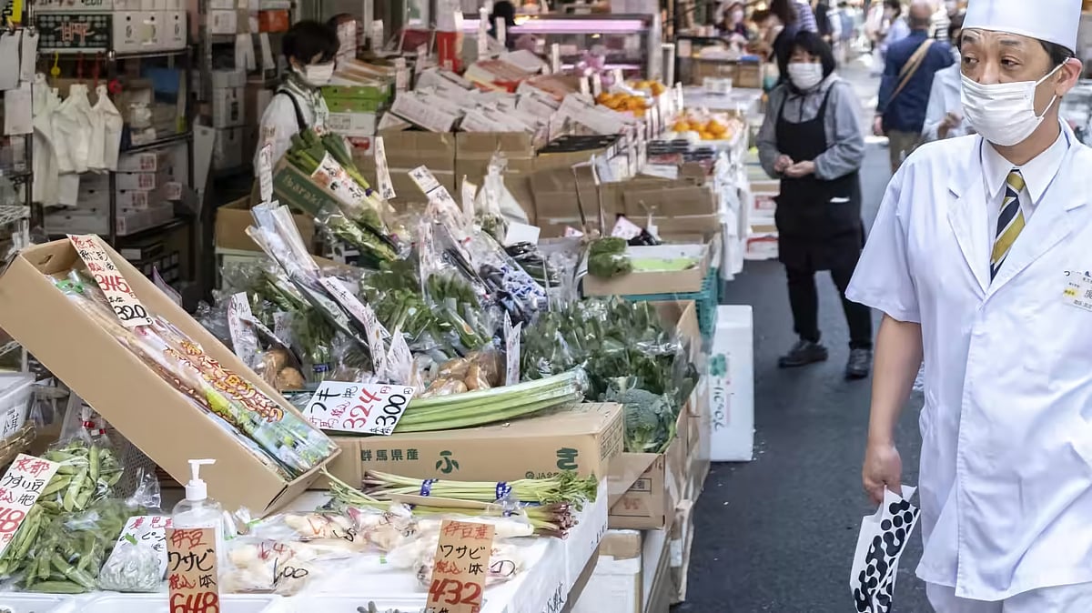 A fishmonger walks through a street market in Tokyo's Tsukiji area on April 22. Accelerating inflation in Japan is hitting consumers in the pocket.