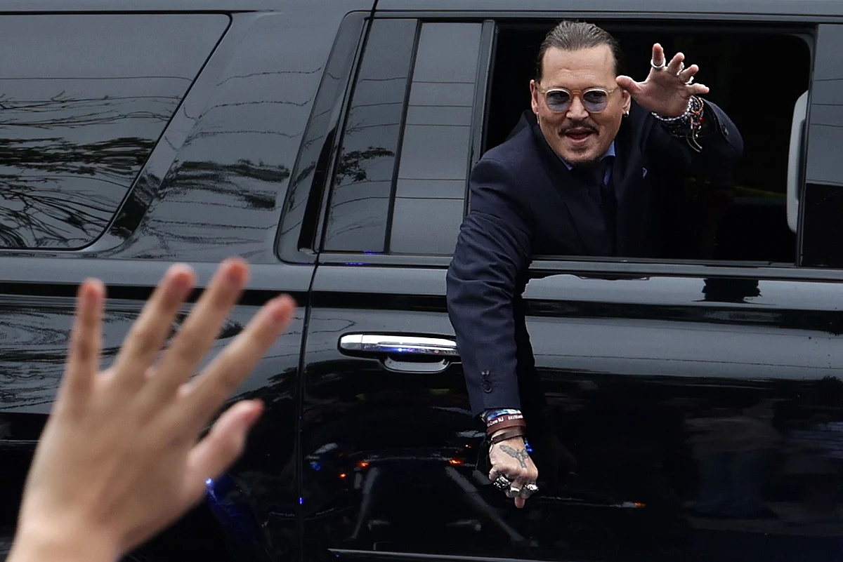 Actor Johnny Depp waves to supporters from his vehicle as he leaves a Fairfax County Courthouse on 27 May 2022 in Fairfax, Virginia