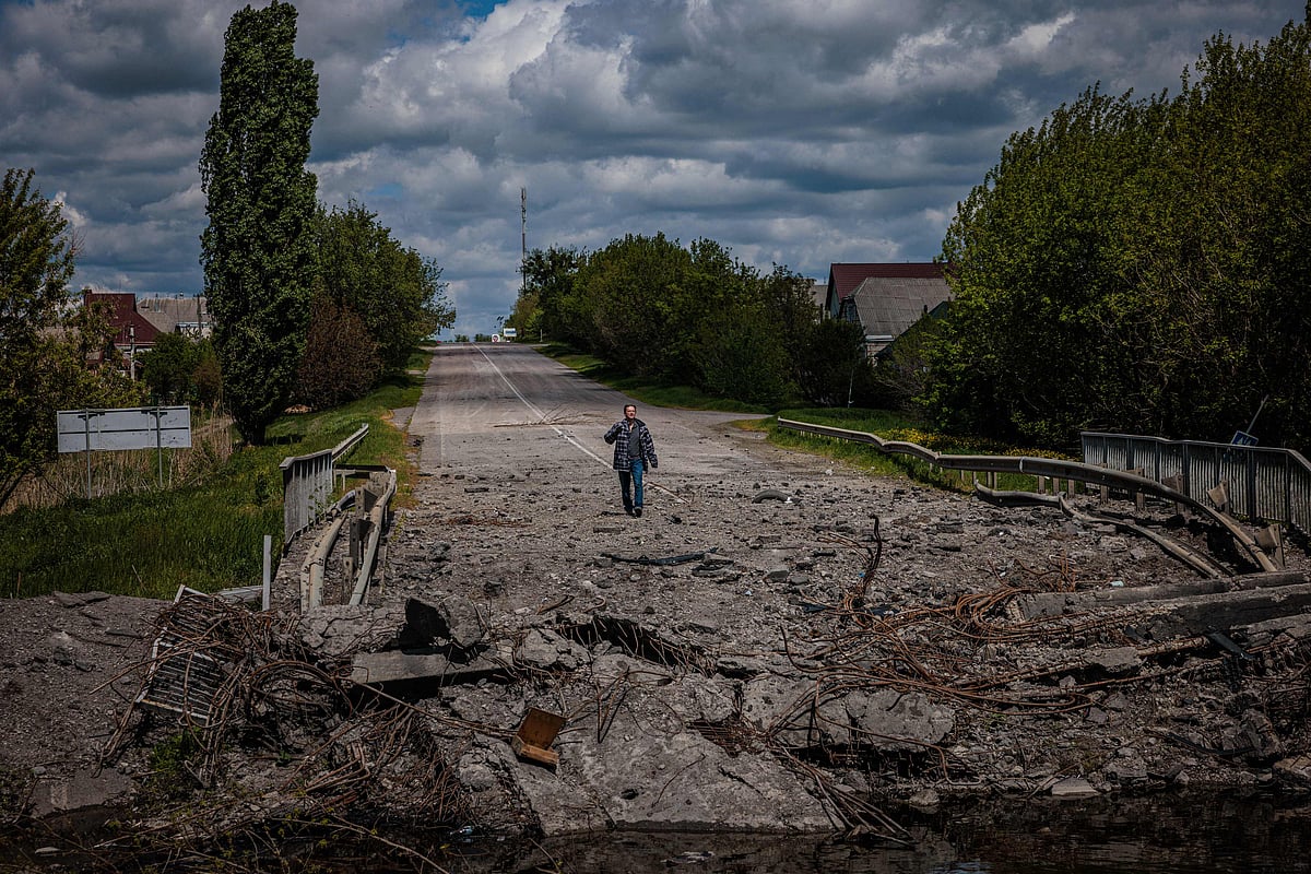 Soldiers of the Kraken Ukrainian special forces unit talk to a man at a destroyed bridge on the road near the village of Rus'ka Lozova, north of Kharkiv, on 16 May, 2022