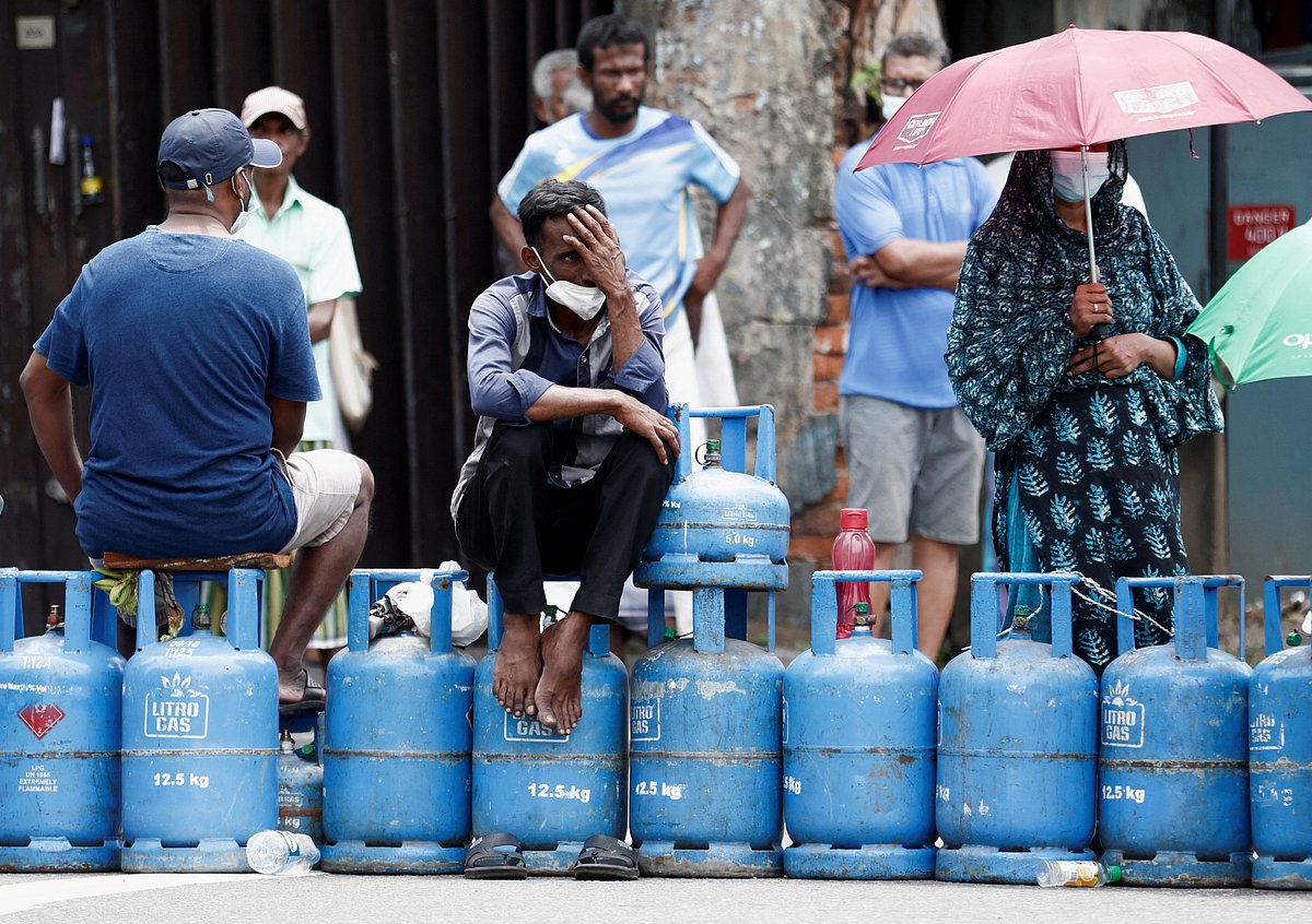 People block a main road as they wait for the gas trucks to arrive at the station to distribute for them, amid the country's economic crisis in Colombo on 8 May, 2022.