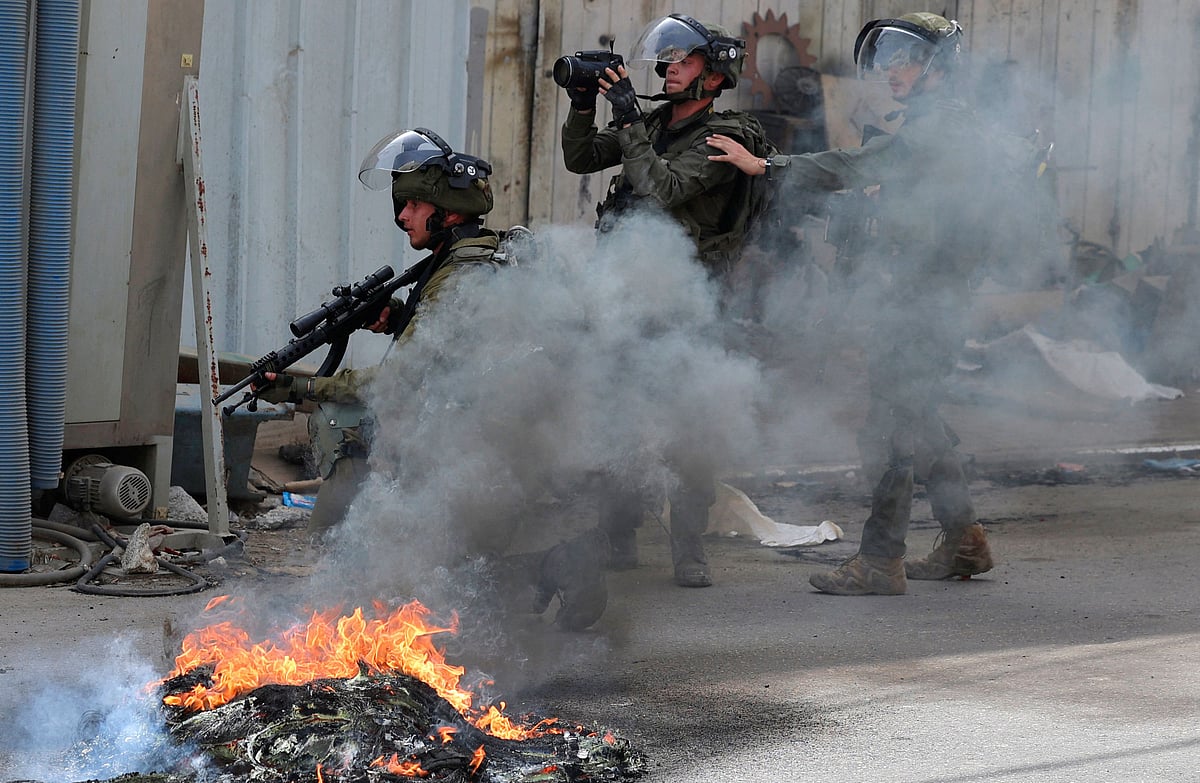 Israeli soldiers take positions during clashes with Palestinian in village of Azzun in the north of the occupied West Bank after the funeral of Yahya Edwan, who was killed during an overnight An Israeli army operation, on 30 April, 2022
