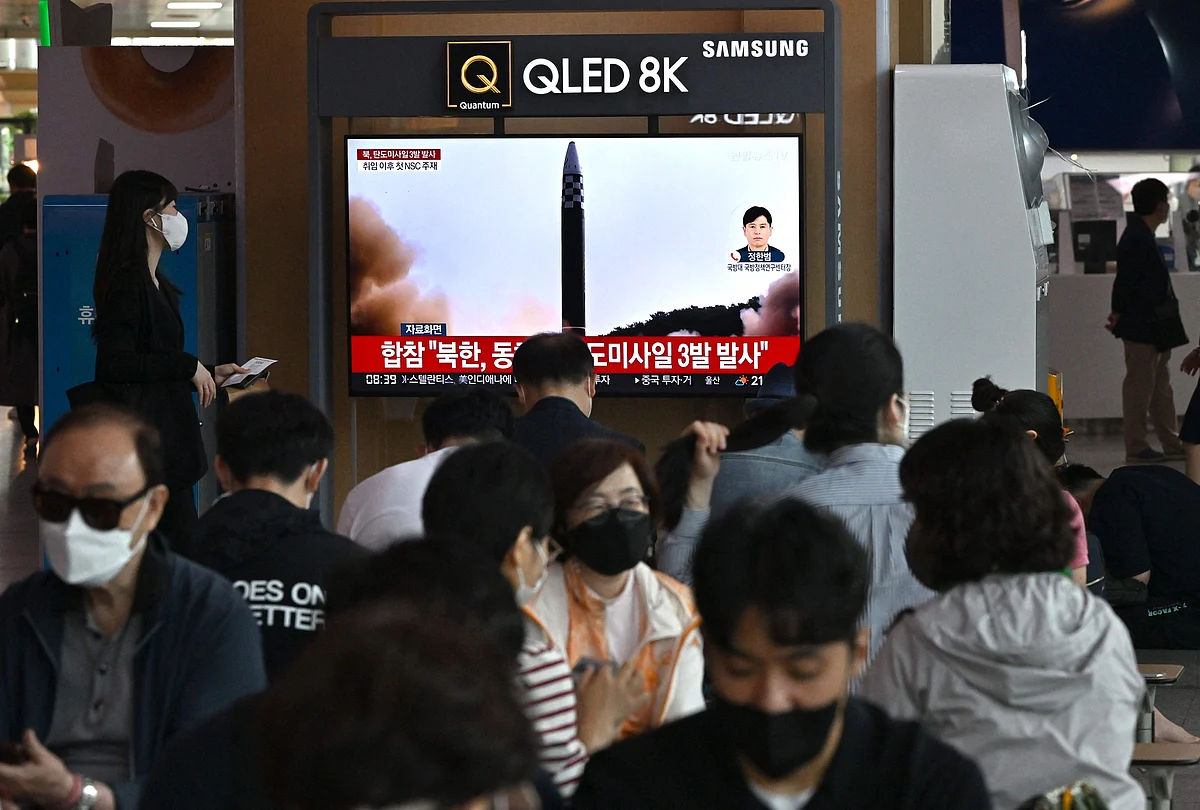 People watch a television screen showing a news broadcast with file footage of a North Korean missile test, at a railway station in Seoul on 25 May, 2022, after North Korea fired three ballistic missiles towards the Sea of Japan according to South Korea's military.