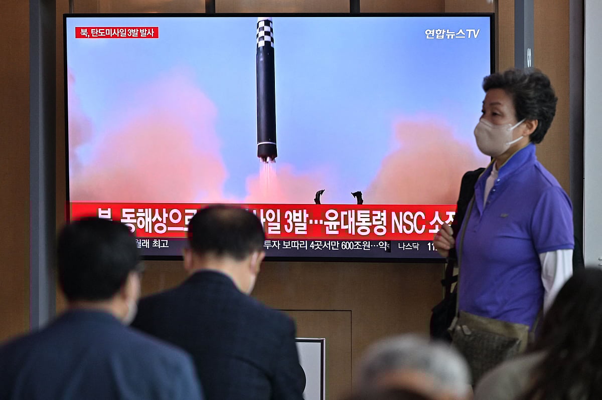 People watch a television screen showing a news broadcast with file footage of a North Korean missile test, at a railway station in Seoul on 25 May, 2022