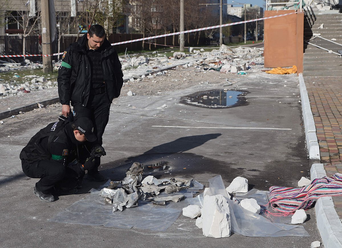 Ukrainian police officers inspect missile debris in front of a damaged building in Odessa, southern Ukraine on 24 April, 2022, which was reportedly hit by missile strike
