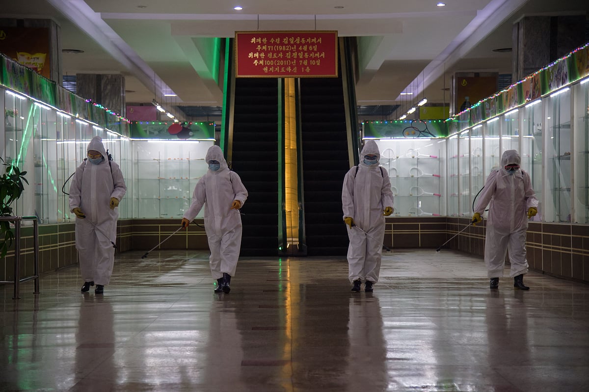 In this file photo taken on 28 December, 2020 health workers spray disinfectant inside the Pyongyang Department Store no. 1 prior to opening for business, in Pyongyang on 28 December, 2020.