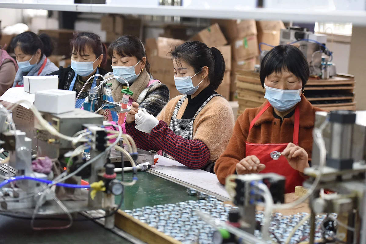 This file photo taken on 31 March, 2022 shows employees working on an assembly line producing speakers at a factory in Linquan county, Fuyang city, in China's eastern Anhui province.