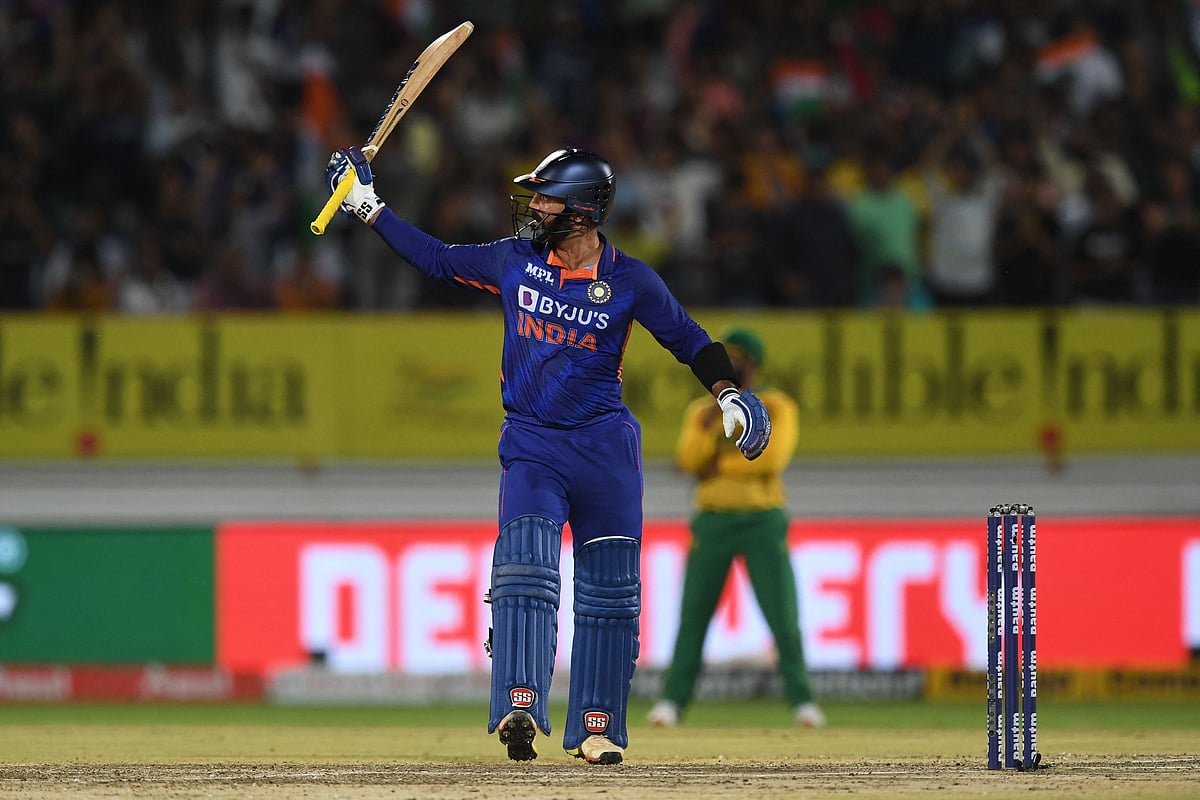 India's Dinesh Karthik raises his bat after scoring a half century (50 runs) during the fourth Twenty20 international cricket match between India and South Africa at the Saurashtra Cricket Association Stadium in Rajkot on 17 June, 2022