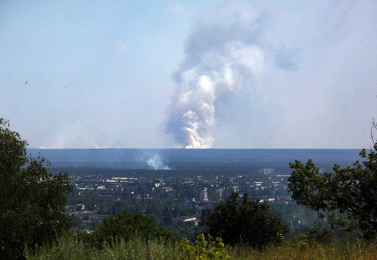 A picture taken on 21 June, 2022 from the town of Lysychansk, shows a large plume of smoke rising on the horizon, behind the town of Severodonetsk