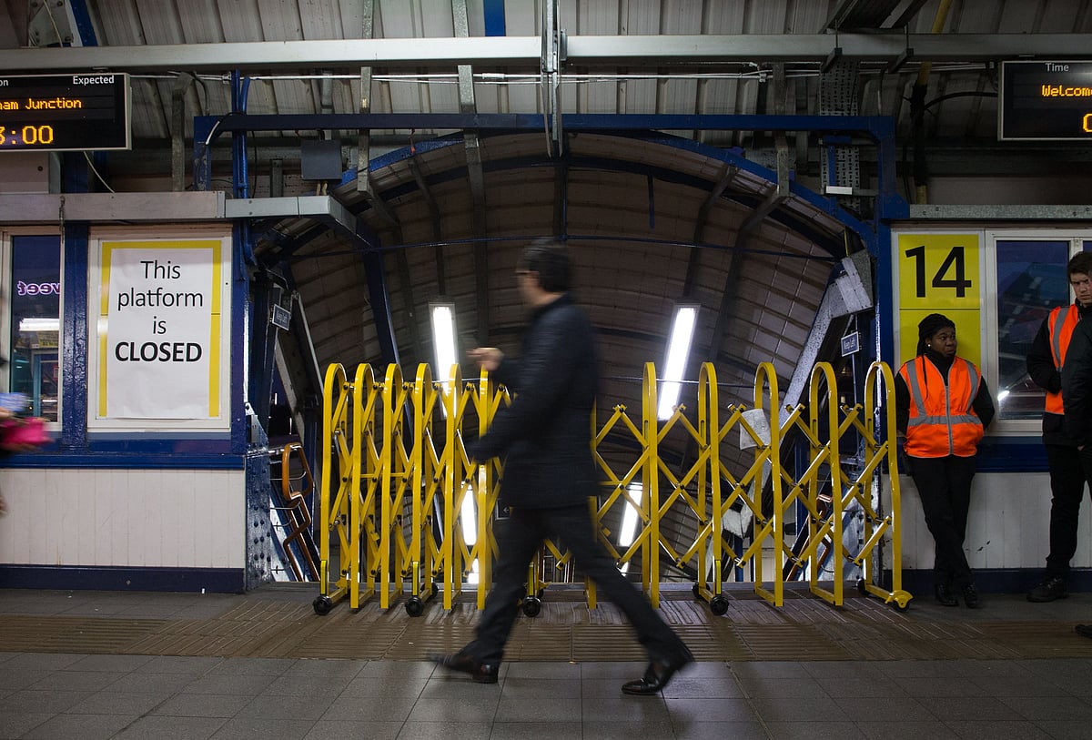 In this file photo taken on 10 January, 2017 a passenger walks past a closed entrance to a platform used by Southern Rail at Clapham Junction station in London on during a Southern Rail drivers strike