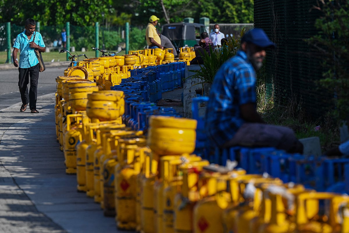 People queue along a street to buy Liquefied Petroleum Gas (LPG) cylinders near the Galle International Cricket Stadium in Galle on June 28, 2022