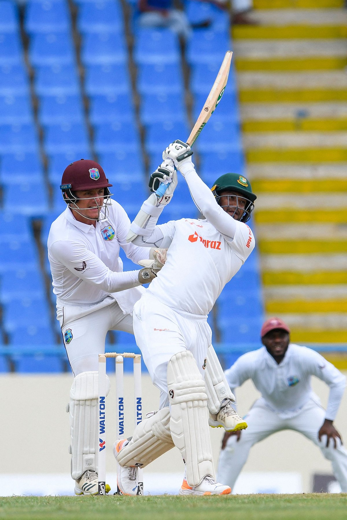 Shakib Al Hasan (R) of Bangladesh hits 6 as Joshua Da Silva (L) of West Indies watches during the 1st day of the 1st Test between Bangladesh and West Indies at Vivian Richards Cricket Stadium in North Sound, Antigua and Barbuda, on 16 June 2022.