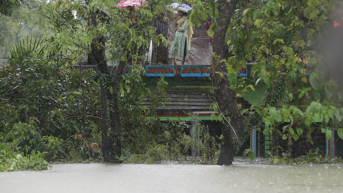 People take shelter on the rooftop of their home inundated by floods. The picture is taken in Sylhet’s Gowainghat on 17 June.