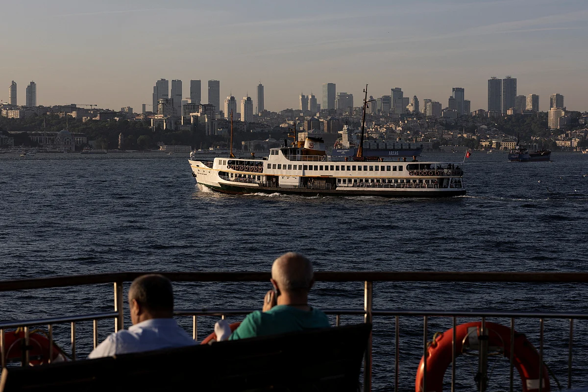 Commuters enjoy a sunny afternoon on board of a ferry as another one sails in the Bosphorus in Istanbul, Turkey on 27 May, 2022