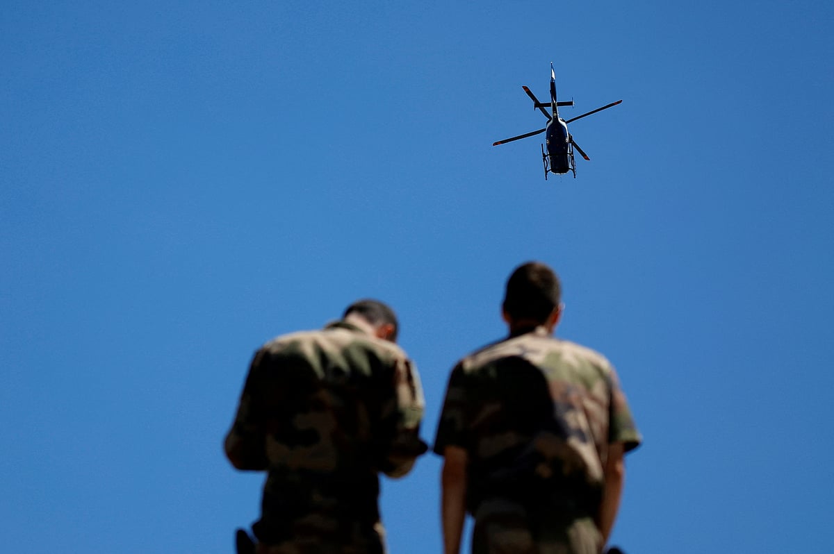 French Air Force soldiers look at a Gendarmerie helicopter during a rehearsal for the traditional Bastille Day military parade in Paris, France on 11 July 2022.