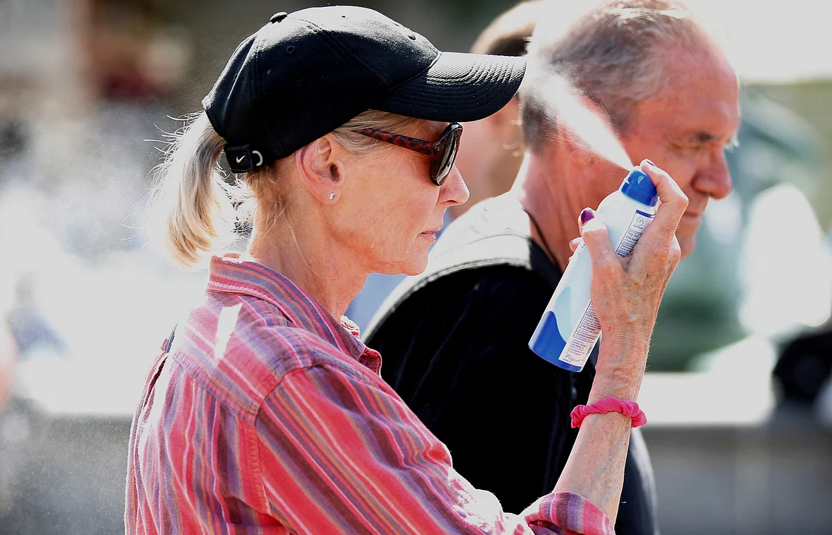 A woman applies a cooling spray as temperatures rise, in Trafalgar Square, London, Britain on 16 July, 2022.