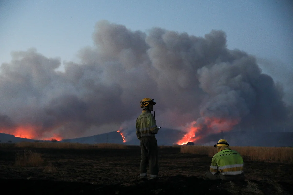 Firefighters guard while the wildfire burns the hills outside Tabara, Zamora, on the second heatwave of the year, in Spain on 18 July, 2022