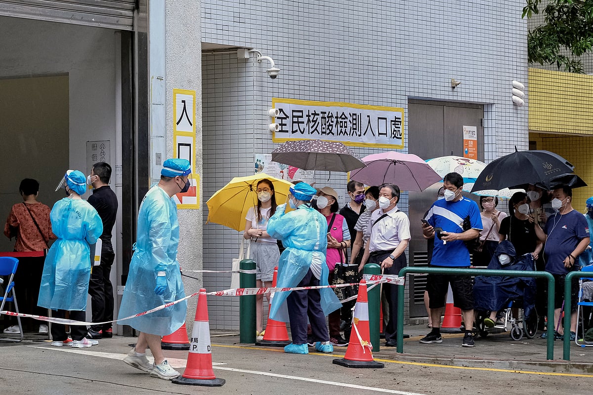 Residents holding umbrellas line up to get tested for the coronavirus disease (COVID-19) in Macau, China on 4 July, 2022
