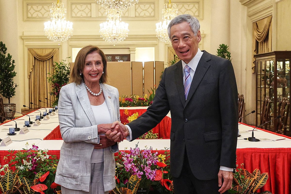This handout picture taken and released by Singapore's Ministry of Communications and Information on 1 August, 2022, shows Singapore's Prime Minister Lee Hsien Loong (R) shaking hands with US Speaker of the House Nancy Pelosi at the Istana Presidential Palace in Singapore during a visit to the Asia-Pacific region