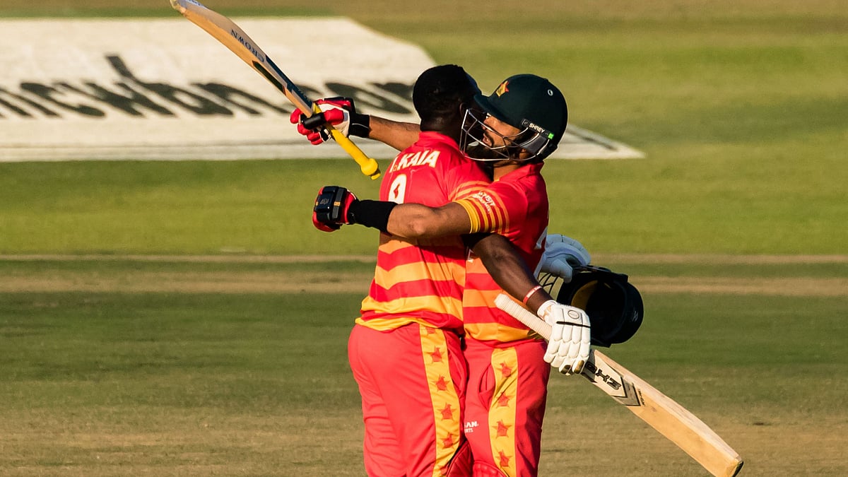 Zimbabwe's Innocent Kaia (L) is congratualted by Zimbabwe's Sikandar Raza (R) after scoring a century (100 runs) during the first one-day international (ODI) cricket match between Zimbabwe and Bangladesh at the Harare Sports Club on 5 August 2022.