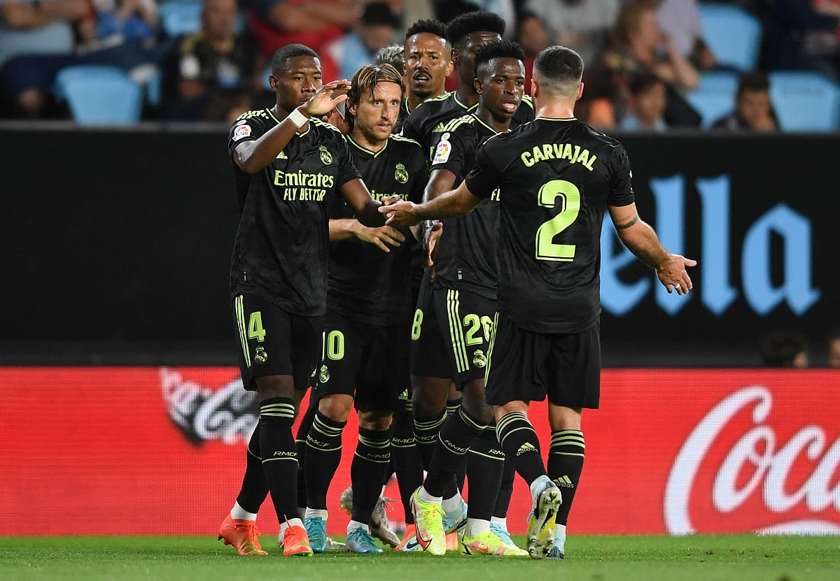 Real Madrid's players celebrate their third goal scored by Real Madrid's Brazilian forward Vinicius Junior (2R) during the Spanish League football match between RC Celta de Vigo and Real Madrid CF at the Balaidos stadium in Vigo on 20 August, 2022