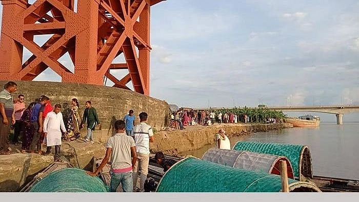 People watch as Padma river erosion eats up land near a pillar of Hardinge Bridge in Ishwardi, Pabna