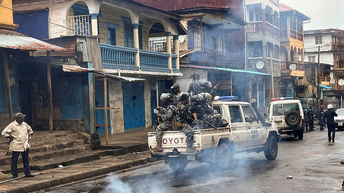 Riot police patrol as they pass smoke rising from a roadblock during anti-government protests in Freetown, Sierra Leone 10 August 2022.