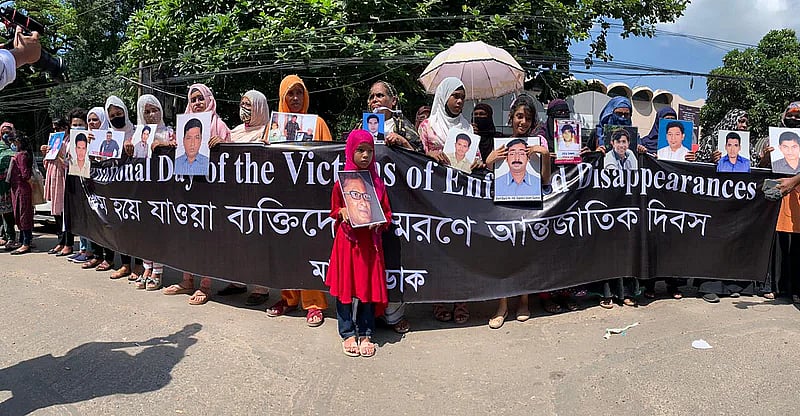 Participants holding photographs of victims of enforced disappearance at human chain in the city's Shahbagh on 30 August 2022