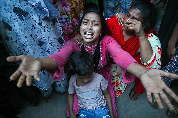 Deceased Sumon's wife Zannat Akter laments with her son Raquib in her lap in front of Hatirjheel police station on 20 August 2022