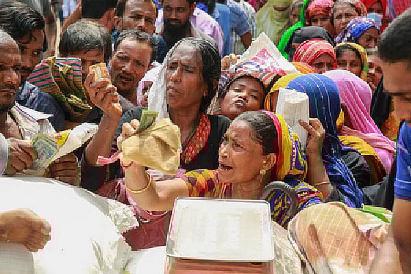 People throng around an OMS truck to buy rice in capital's Mohammadpur area.