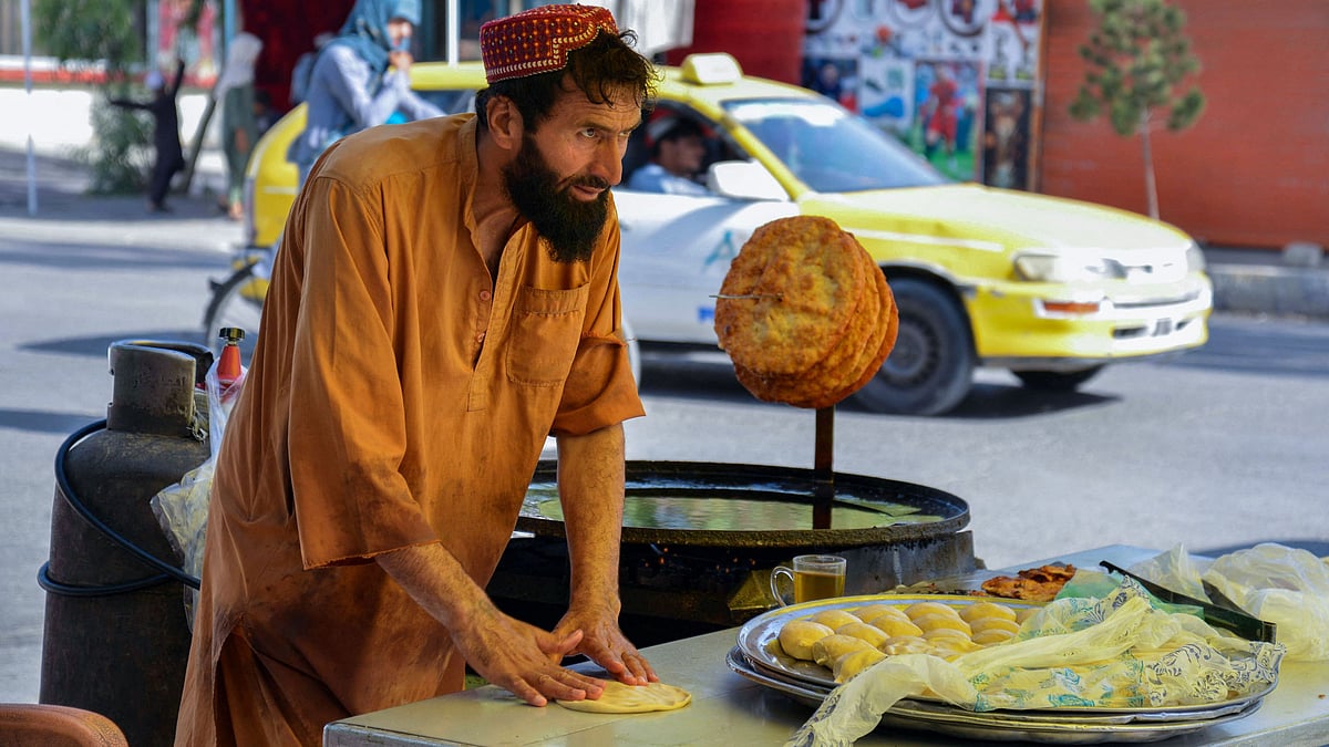 This photo taken on 18 July 2022, shows a man preparing breakfast in a stall in Kandahar.
